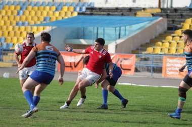 Odessa, Ukrayna - 29 Eylül 2019: Odessa ragbi takımı - Kiev Politeknik. Rugby oyuncularının top için yoğun mücadelesi. Stadyumun yeşil sahasında dinamik bir oyun. Vahşi Rugby Dövüşü