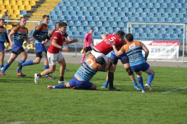 Odessa, Ukrayna - 29 Eylül 2019: Odessa ragbi takımı - Kiev Politeknik. Rugby oyuncularının top için yoğun mücadelesi. Stadyumun yeşil sahasında dinamik bir oyun. Vahşi Rugby Dövüşü