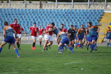Odessa, Ukrayna - 29 Eylül 2019: Odessa ragbi takımı - Kiev Politeknik. Rugby oyuncularının top için yoğun mücadelesi. Stadyumun yeşil sahasında dinamik bir oyun. Vahşi Rugby Dövüşü