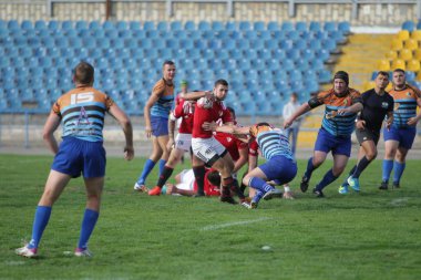 Odessa, Ukrayna - 29 Eylül 2019: Odessa ragbi takımı - Kiev Politeknik. Rugby oyuncularının top için yoğun mücadelesi. Stadyumun yeşil sahasında dinamik bir oyun. Vahşi Rugby Dövüşü