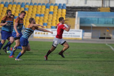 Odessa, Ukrayna - 29 Eylül 2019: Odessa ragbi takımı - Kiev Politeknik. Rugby oyuncularının top için yoğun mücadelesi. Stadyumun yeşil sahasında dinamik bir oyun. Vahşi Rugby Dövüşü