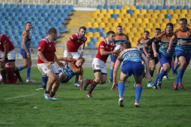 Odessa, Ukrayna - 29 Eylül 2019: Odessa ragbi takımı - Kiev Politeknik. Rugby oyuncularının top için yoğun mücadelesi. Stadyumun yeşil sahasında dinamik bir oyun. Vahşi Rugby Dövüşü