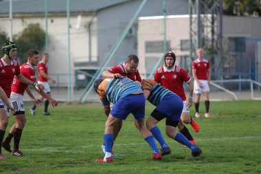 Odessa, Ukrayna - 29 Eylül 2019: Odessa ragbi takımı - Kiev Politeknik. Rugby oyuncularının top için yoğun mücadelesi. Stadyumun yeşil sahasında dinamik bir oyun. Vahşi Rugby Dövüşü