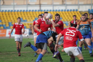 Odessa, Ukrayna - 29 Eylül 2019: Odessa ragbi takımı - Kiev Politeknik. Rugby oyuncularının top için yoğun mücadelesi. Stadyumun yeşil sahasında dinamik bir oyun. Vahşi Rugby Dövüşü