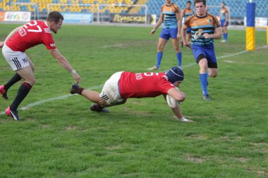 Odessa, Ukrayna - 29 Eylül 2019: Odessa ragbi takımı - Kiev Politeknik. Rugby oyuncularının top için yoğun mücadelesi. Stadyumun yeşil sahasında dinamik bir oyun. Vahşi Rugby Dövüşü