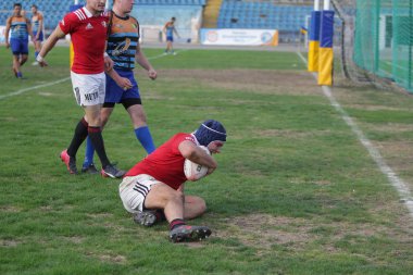 Odessa, Ukrayna - 29 Eylül 2019: Odessa ragbi takımı - Kiev Politeknik. Rugby oyuncularının top için yoğun mücadelesi. Stadyumun yeşil sahasında dinamik bir oyun. Vahşi Rugby Dövüşü