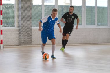 Odessa, Ukrayna - 6 Ekim 2019: Tanımlanamayan yerel takım oyuncuları parke zeminde kapalı alanda futbol oynuyorlar. Bir spor maçının doğru anı kapalı bir salonda, kapalı bir futbol salonunda