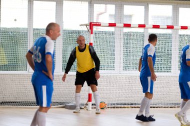 Odessa, Ukrayna - 6 Ekim 2019: Tanımlanamayan yerel takım oyuncuları parke zeminde kapalı alanda futbol oynuyorlar. Bir spor maçının doğru anı kapalı bir salonda, kapalı bir futbol salonunda