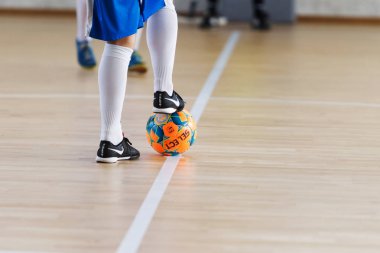 Odessa, Ukrayna - 6 Ekim 2019: Tanımlanamayan yerel takım oyuncuları parke zeminde kapalı alanda futbol oynuyorlar. Bir spor maçının doğru anı kapalı bir salonda, kapalı bir futbol salonunda
