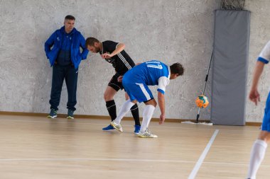 Odessa, Ukrayna - 6 Ekim 2019: Tanımlanamayan yerel takım oyuncuları parke zeminde kapalı alanda futbol oynuyorlar. Bir spor maçının doğru anı kapalı bir salonda, kapalı bir futbol salonunda