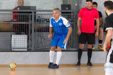 Odessa, Ukrayna - 6 Ekim 2019: Tanımlanamayan yerel takım oyuncuları parke zeminde kapalı alanda futbol oynuyorlar. Bir spor maçının doğru anı kapalı bir salonda, kapalı bir futbol salonunda