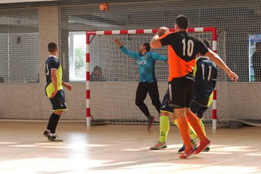 Odessa, Ukrayna - 6 Ekim 2019: Tanımlanamayan yerel takım oyuncuları parke zeminde kapalı alanda futbol oynuyorlar. Bir spor maçının doğru anı kapalı bir salonda, kapalı bir futbol salonunda