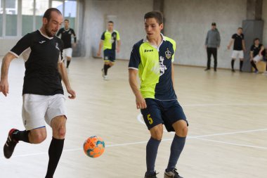Odessa, Ukrayna - 6 Ekim 2019: Tanımlanamayan yerel takım oyuncuları parke zeminde kapalı alanda futbol oynuyorlar. Bir spor maçının doğru anı kapalı bir salonda, kapalı bir futbol salonunda