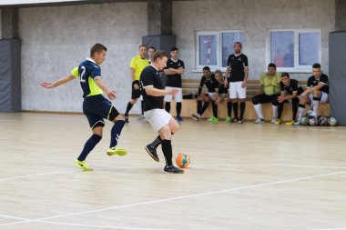 Odessa, Ukrayna - 6 Ekim 2019: Tanımlanamayan yerel takım oyuncuları parke zeminde kapalı alanda futbol oynuyorlar. Bir spor maçının doğru anı kapalı bir salonda, kapalı bir futbol salonunda