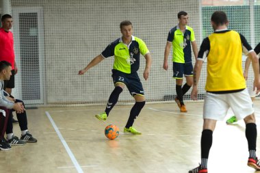 Odessa, Ukrayna - 6 Ekim 2019: Tanımlanamayan yerel takım oyuncuları parke zeminde kapalı alanda futbol oynuyorlar. Bir spor maçının doğru anı kapalı bir salonda, kapalı bir futbol salonunda