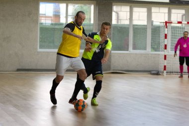 Odessa, Ukrayna - 6 Ekim 2019: Tanımlanamayan yerel takım oyuncuları parke zeminde kapalı alanda futbol oynuyorlar. Bir spor maçının doğru anı kapalı bir salonda, kapalı bir futbol salonunda