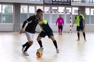 Odessa, Ukrayna - 6 Ekim 2019: Tanımlanamayan yerel takım oyuncuları parke zeminde kapalı alanda futbol oynuyorlar. Bir spor maçının doğru anı kapalı bir salonda, kapalı bir futbol salonunda