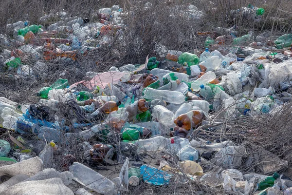 Poured garbage on Sea coast is left by tourists and vacationers. Dirty sea sandy shore of  Sea. Environmental pollution. Environmental problem has negative impact. Empty used dirty plastic bottles