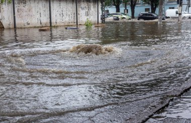 Odessa, Ukrayna - 28 Mayıs 2020: sel baskınları sırasında sel basmış yolda araba kullanmak. Arabalar suda yüzer, sokakları su basar. Arabanın üzerine su sıçradı. Büyük su birikintileriyle dolu şehir yolu.