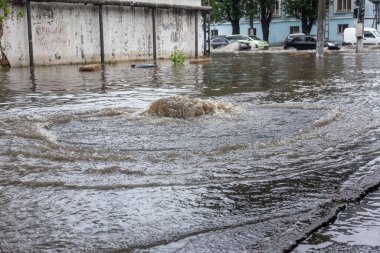 Odessa, Ukrayna - 28 Mayıs 2020: sel baskınları sırasında sel basmış yolda araba kullanmak. Arabalar suda yüzer, sokakları su basar. Arabanın üzerine su sıçradı. Büyük su birikintileriyle dolu şehir yolu.