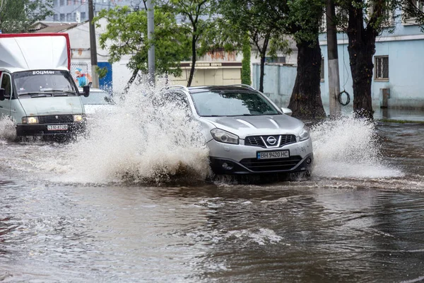 ウクライナのオデッサ 2020年5月28日 豪雨による洪水時の浸水した道路上で車を運転する 車の水には 洪水の通りに浮かぶ 車の上でスプラッシュ 大規模な水たまりと洪水都市道路 — ストック写真