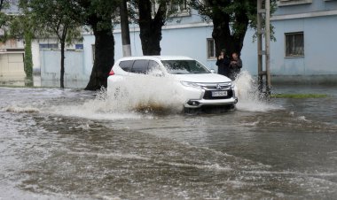 Odessa, Ukrayna - 28 Mayıs 2020: sel baskınları sırasında sel basmış yolda araba kullanmak. Arabalar suda yüzer, sokakları su basar. Arabanın üzerine su sıçradı. Büyük su birikintileriyle dolu şehir yolu.