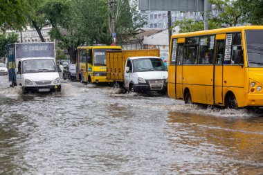 Odessa, Ukrayna - 28 Mayıs 2020: sel baskınları sırasında sel basmış yolda araba kullanmak. Arabalar suda yüzer, sokakları su basar. Arabanın üzerine su sıçradı. Büyük su birikintileriyle dolu şehir yolu.