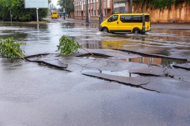 Odessa, Ukrayna - 28 Mayıs 2020: sel baskınları sırasında sel basmış yolda araba kullanmak. Arabalar suda yüzer, sokakları su basar. Arabanın üzerine su sıçradı. Büyük su birikintileriyle dolu şehir yolu.