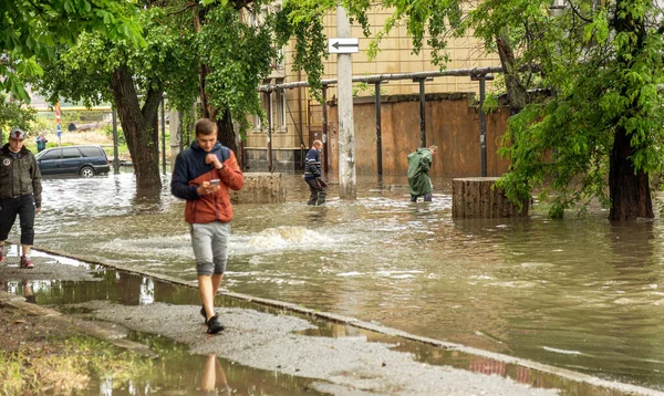 Odessa, Ukrayna - 28 Mayıs 2020: sel baskınları sırasında sel basmış yolda araba kullanmak. Arabalar suda yüzer, sokakları su basar. Arabanın üzerine su sıçradı. Büyük su birikintileriyle dolu şehir yolu.
