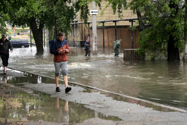 Odessa, Ukrayna - 28 Mayıs 2020: sel baskınları sırasında sel basmış yolda araba kullanmak. Arabalar suda yüzer, sokakları su basar. Arabanın üzerine su sıçradı. Büyük su birikintileriyle dolu şehir yolu.
