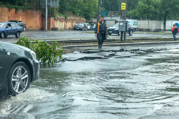 Odessa, Ukrayna - 28 Mayıs 2020: sel baskınları sırasında sel basmış yolda araba kullanmak. Arabalar suda yüzer, sokakları su basar. Arabanın üzerine su sıçradı. Büyük su birikintileriyle dolu şehir yolu.