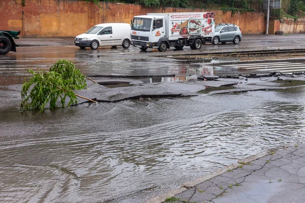 Odessa, Ukrayna - 28 Mayıs 2020: sel baskınları sırasında sel basmış yolda araba kullanmak. Arabalar suda yüzer, sokakları su basar. Arabanın üzerine su sıçradı. Büyük su birikintileriyle dolu şehir yolu.