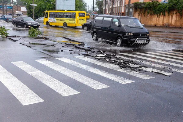 Odessa, Ukrayna - 28 Mayıs 2020: sel baskınları sırasında sel basmış yolda araba kullanmak. Arabalar suda yüzer, sokakları su basar. Arabanın üzerine su sıçradı. Büyük su birikintileriyle dolu şehir yolu.
