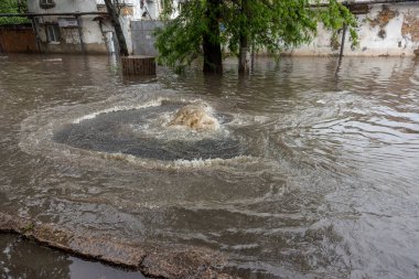 Odessa, Ukrayna - 28 Mayıs 2020: sel baskınları sırasında sel basmış yolda araba kullanmak. Arabalar suda yüzer, sokakları su basar. Arabanın üzerine su sıçradı. Büyük su birikintileriyle dolu şehir yolu.