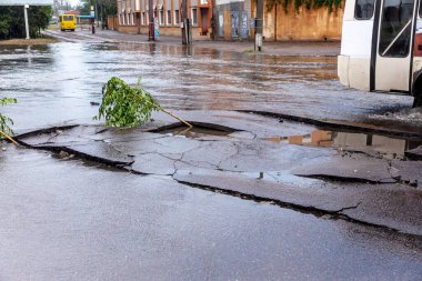 Şiddetli yağmurların yol açtığı sel baskını sırasında sel basmış yolda bir araba. Arabalar suda yüzer, sokakları su basar. Arabanın üzerine su sıçradı. Büyük su birikintileriyle dolu şehir yolu. Şehirde sağanak yağış ardından sel