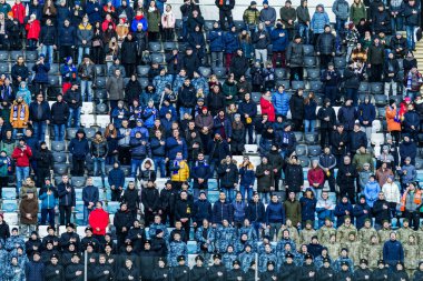 ODESSA, UKRAINE -2 Mart 2019: Shakhtar (Donetsk) maçı sırasında stadyumun tribünlerinde taraftarlar toplandı. Stadyumdaki izleyiciler. Fayer, stadyumun ışıkları yanıyor.