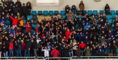 ODESSA, UKRAINE -2 Mart 2019: Shakhtar (Donetsk) maçı sırasında stadyumun tribünlerinde taraftarlar toplandı. Stadyumdaki izleyiciler. Fayer, stadyumun ışıkları yanıyor.