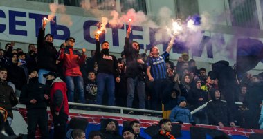 ODESSA, UKRAINE -2 Mart 2019: Shakhtar (Donetsk) maçı sırasında stadyumun tribünlerinde taraftarlar toplandı. Stadyumdaki izleyiciler. Fayer, stadyumun ışıkları yanıyor.