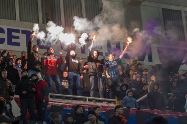 ODESSA, UKRAINE -2 Mart 2019: Shakhtar (Donetsk) maçı sırasında stadyumun tribünlerinde taraftarlar toplandı. Stadyumdaki izleyiciler. Fayer, stadyumun ışıkları yanıyor.