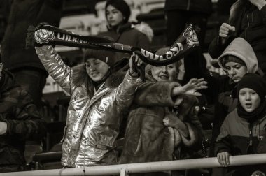 ODESSA, UKRAINE -2 Mart 2019: Shakhtar (Donetsk) maçı sırasında stadyumun tribünlerinde taraftarlar toplandı. Stadyumdaki izleyiciler. Fayer, stadyumun ışıkları yanıyor.