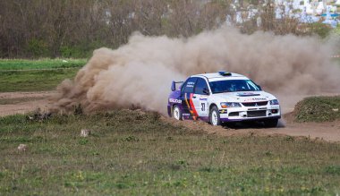 ODESSA, UKRAINE - 30 Nisan 2017: Geleneksel ralli Autocross Şampiyonası. Yarış arabası tehlikeli. Dik bir yarış pistine giriyor, etrafa saçılıyor, toz püskürtüyor. Aşırı ralli otomobili