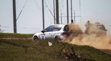 ODESSA, UKRAINE - 30 Nisan 2017: Geleneksel ralli Autocross Şampiyonası. Yarış arabası tehlikeli. Dik bir yarış pistine giriyor, etrafa saçılıyor, toz püskürtüyor. Aşırı ralli otomobili