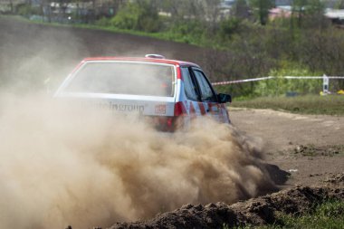 ODESSA, UKRAINE - 30 Nisan 2017: Geleneksel ralli Autocross Şampiyonası. Yarış arabası tehlikeli. Dik bir yarış pistine giriyor, etrafa saçılıyor, toz püskürtüyor. Aşırı ralli otomobili