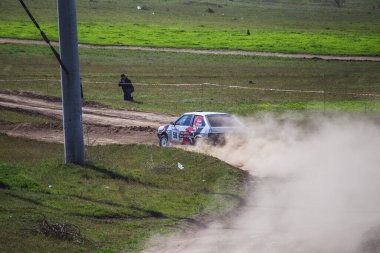 ODESSA, UKRAINE - 30 Nisan 2017: Geleneksel ralli Autocross Şampiyonası. Yarış arabası tehlikeli. Dik bir yarış pistine giriyor, etrafa saçılıyor, toz püskürtüyor. Aşırı ralli otomobili