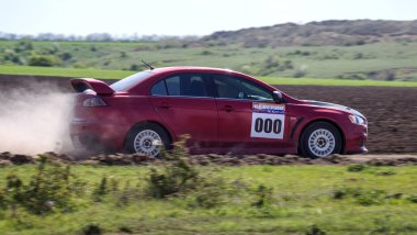 ODESSA, UKRAINE - 30 Nisan 2017: Geleneksel ralli Autocross Şampiyonası. Yarış arabası tehlikeli. Dik bir yarış pistine giriyor, etrafa saçılıyor, toz püskürtüyor. Aşırı ralli otomobili