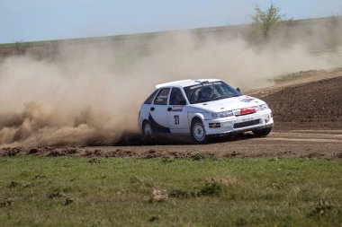 ODESSA, UKRAINE - 30 Nisan 2017: Geleneksel ralli Autocross Şampiyonası. Yarış arabası tehlikeli. Dik bir yarış pistine giriyor, etrafa saçılıyor, toz püskürtüyor. Aşırı ralli otomobili