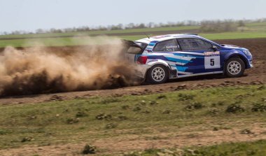 ODESSA, UKRAINE - 30 Nisan 2017: Geleneksel ralli Autocross Şampiyonası. Yarış arabası tehlikeli. Dik bir yarış pistine giriyor, etrafa saçılıyor, toz püskürtüyor. Aşırı ralli otomobili