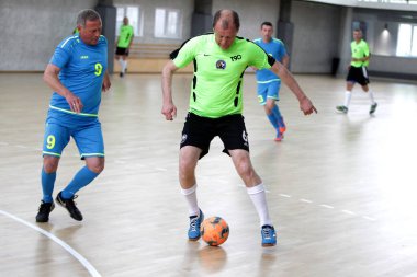 Odessa, Ukrayna - 29 Mayıs 2020: 50 + gaziler arasında futsal kupa play-off maçı. Futsal, spor salonunun büyük sahnesinde, modern oyun alanını kapsıyor. Koridorda yoğun bir mini futbol maçı var. Parke üzerinde