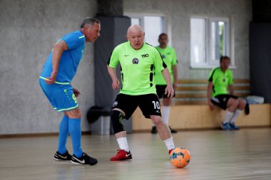 Odessa, Ukrayna - 29 Mayıs 2020: 50 + gaziler arasında futsal kupa play-off maçı. Futsal, spor salonunun büyük sahnesinde, modern oyun alanını kapsıyor. Koridorda yoğun bir mini futbol maçı var. Parke üzerinde