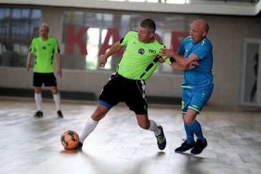 Odessa, Ukrayna - 29 Mayıs 2020: 50 + gaziler arasında futsal kupa play-off maçı. Futsal, spor salonunun büyük sahnesinde, modern oyun alanını kapsıyor. Koridorda yoğun bir mini futbol maçı var. Parke üzerinde